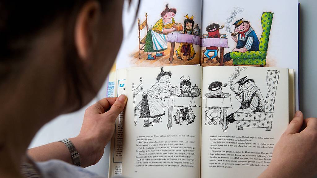ARCHIV - Eine Frau hält in Stuttgart eine alte (vorn) und eine neue Ausgabe des Kinderbuchs «Jim Knopf und die wilde 13» des Autors Michael Ende in den Händen. Foto: picture alliance / dpa