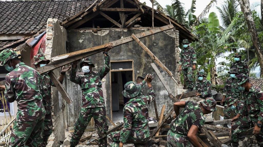 Beträchtliche Schäden und Tote nach dem Erdbeben: Einsatzkräfte inspizieren die Schäden an einem Haus in Mandalawangi auf Java.