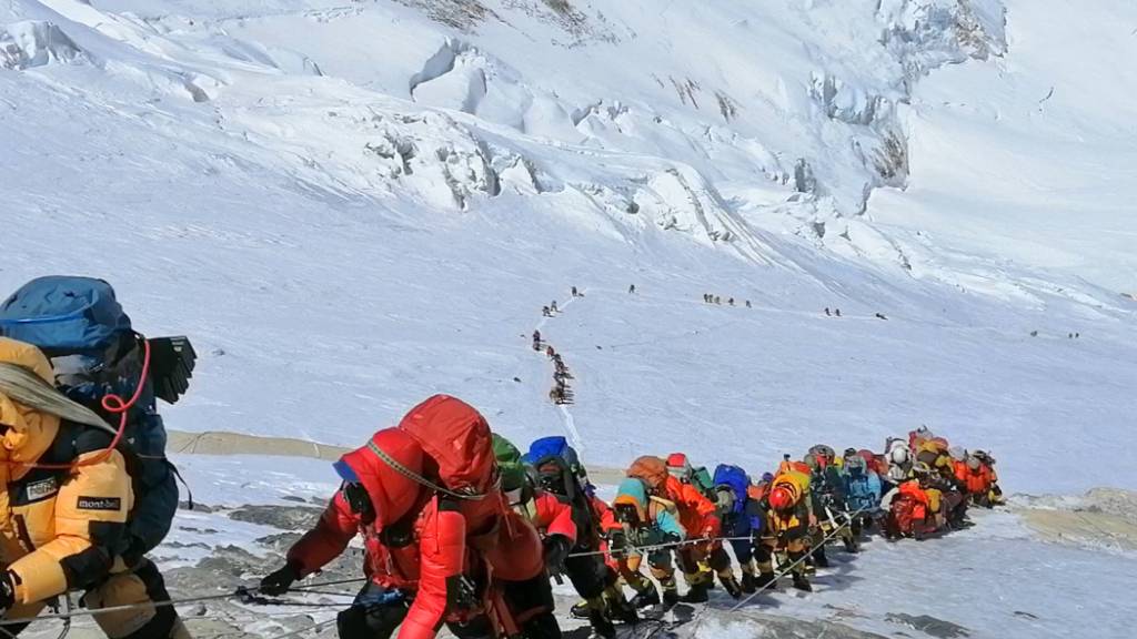 ARCHIV - In einer langer Schlange klettern Bergsteiger auf einem Pfad knapp unterhalb von Lager vier. Trotz Pandemie gibt es auf dem Mount Everest einen Besucherrekord. Foto: Rizza Alee/AP/dpa