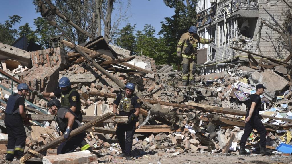 Ukrainische Rettungskräfte arbeiten nach einem russischen Angriff auf Orichiw in den Trümmern eines zerstörten Gebäudes. Foto: Andriy Andriyenko/AP/dpa