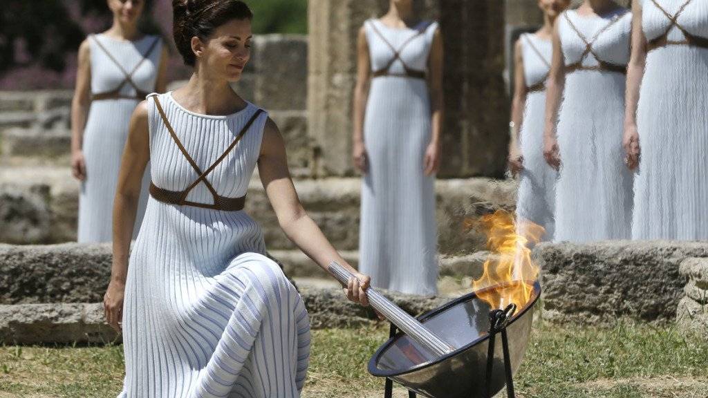 Eine Tänzerin entfacht das olympische Feuer während der Zeremonie im antiken Olympia in Griechenland