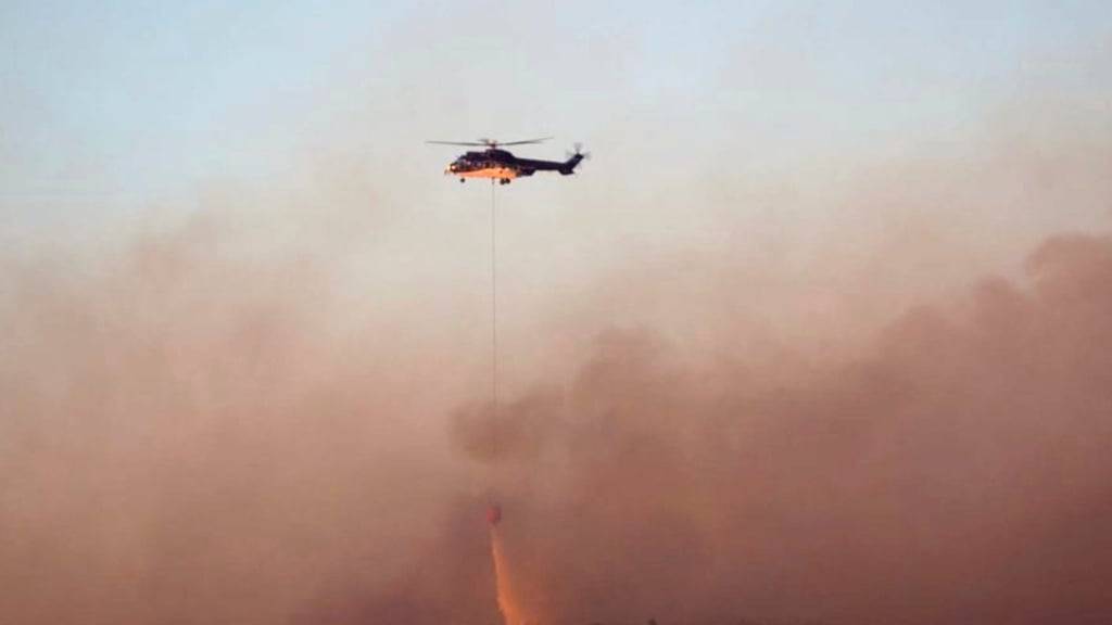 HANDOUT - Das Handout der Feuerwehr vom 17.07.2025 zeigt, wie ein Hubschrauber Flüssigkeit zur Löschung eines Flächenbrands im Süden Frankreichs abwirft. Mehr als 1.000 Feuerwehrleute kämpfen gegen die Flammen, die sich auf rund 240 Hektar erstreckten. Foto: ---/Pompiers13 via AP/dpa