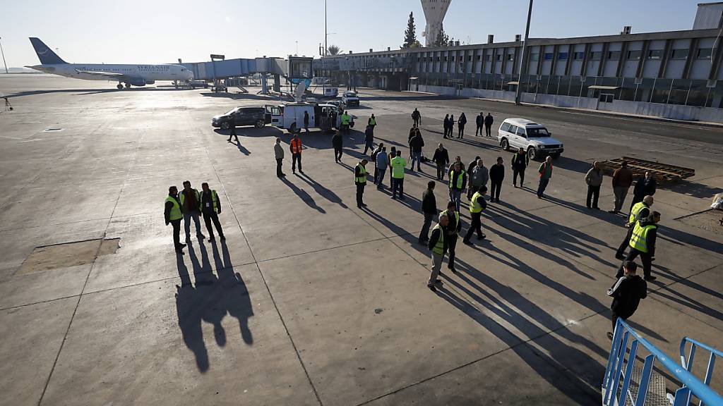 dpatopbilder - Bodenpersonal bereitet ein Flugzeug der Syrian Air vor dem Start vor, als der Flughafen in Damaskus, Syrien, wieder für Inlandsflüge geöffnet wird. Foto: Omar Sanadiki/AP/dpa