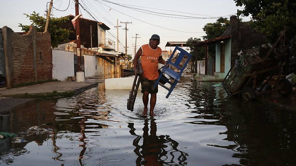 Ein Mann trägt Habseligkeiten zu einer Notunterkunft in Paraguays Hauptstadt Asuncion. Bei Überschwemmungen im Land sind mindestens vier Menschen ums Leben gekommen.