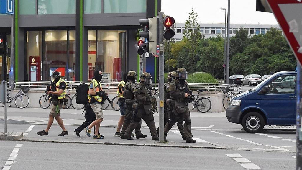 Nach der Schiesserei mit mehreren Toten in einem EInkaufszentrum in München patrouillieren Spezialeinheiten der Polizei vor dem Gebäude.