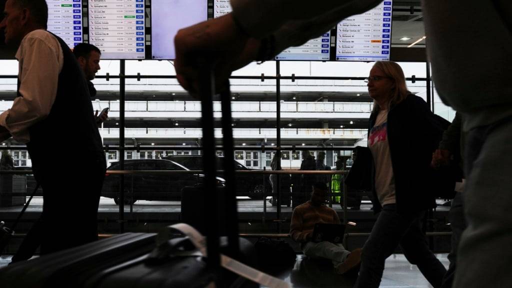 ARCHIV - Reisende gehen mit ihrem Gepäck im Terminal 3 des O'Hare International Airport. Foto: Nam Y. Huh/AP/dpa