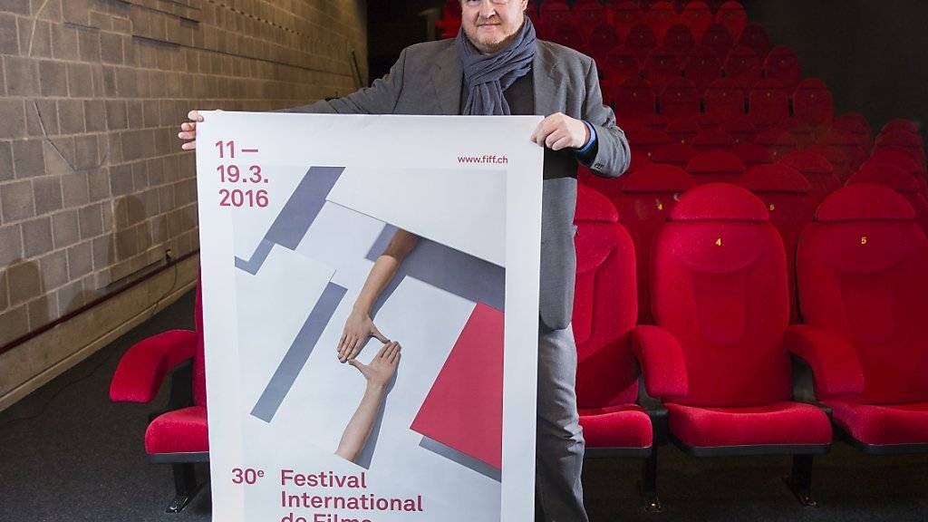 Thierry Jobin, künstlerischer Leiter des FIFF (Festival International de Films de Fribourg), zeigt das Festivalplakat.