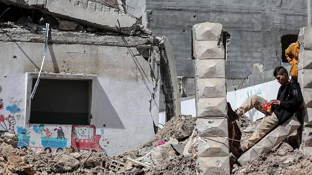 Ein junger Palästinenser steht nach Einsätzen der israelischen Armee im Lager Nur Shams in der Stadt Tulkarm inmitten von beschädigten Gebäuden. Foto: Ayman Nobani/dpa