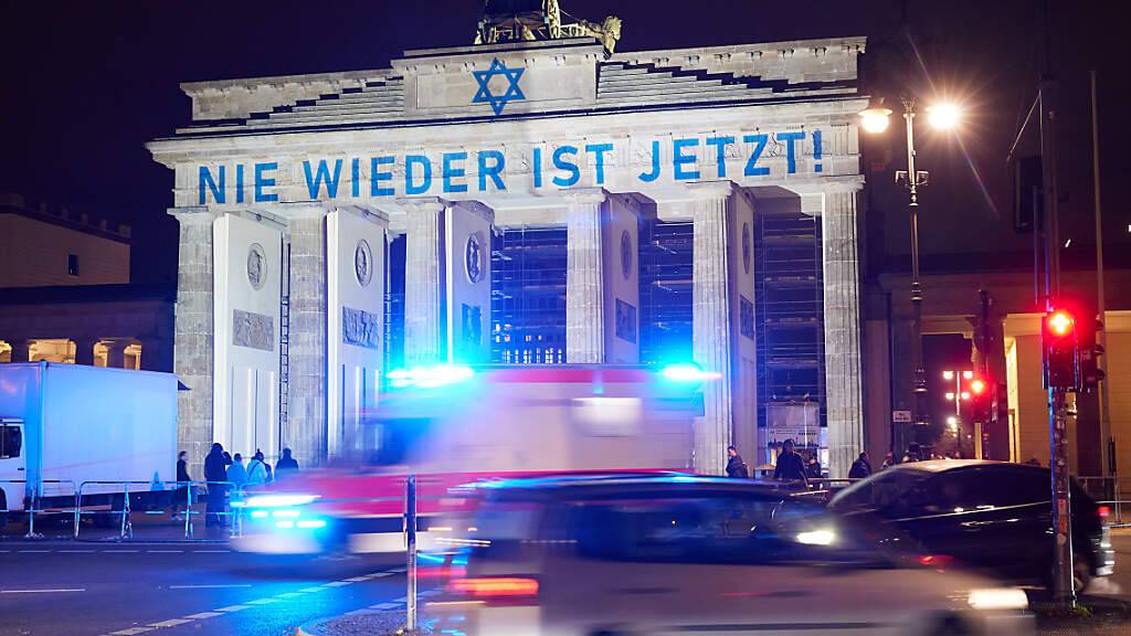 Der Schriftzug «Nie wieder ist jetzt» wird zum 85. Jahrestag der Pogromnacht an das Brandenburger Tor projiziert. In der Nacht vom 9. zum 10. November 1938 brannten die Nazis deutschlandweit Synagogen nieder, misshandelten Jüdinnen und Juden, verwüsteten ihre Wohnungen und Geschäfte. Foto: Joerg Carstensen/dpa
