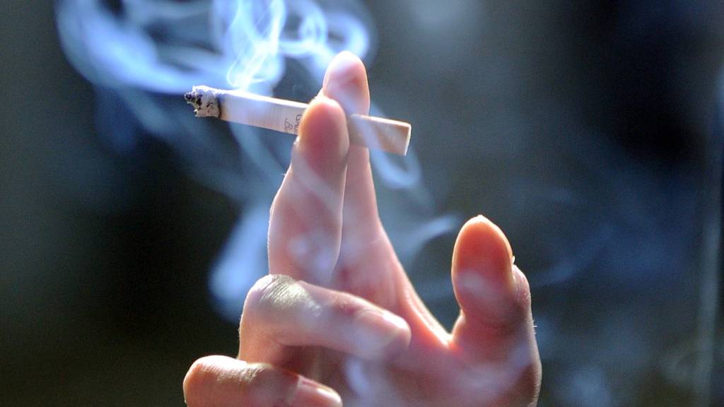 ARCHIV - Eine Hand hält eine Zigarette. Foto: Jens Kalaene/zb/dpa