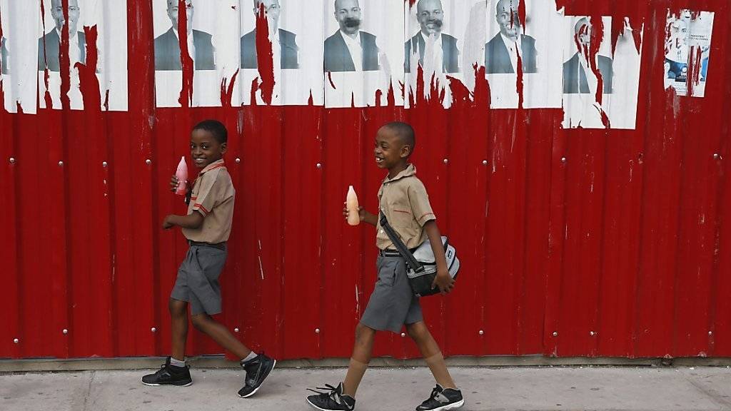 Zwei Kinder unter Wahlplakaten von Jovenel Moïse - er hat die Präsidentenwahl in Haiti laut Wahlkommission gewonnen. (Archiv)