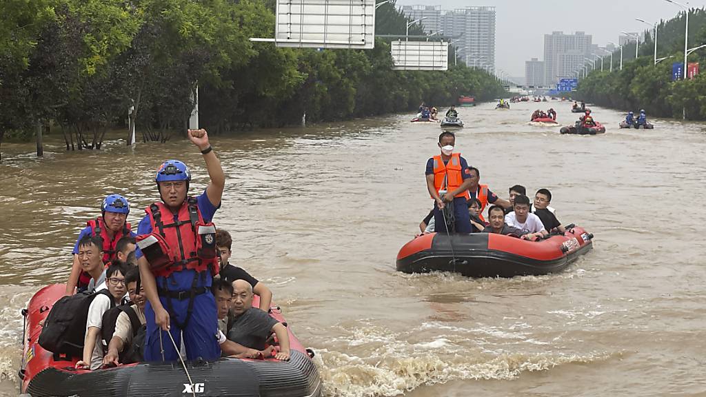 Einwohner werden mit Schlauchbooten durch das Hochwasser in Zhuozhou in der nordchinesischen Provinz Hebei, südlich von Peking, evakuiert. Foto: Andy Wong/AP/dpa