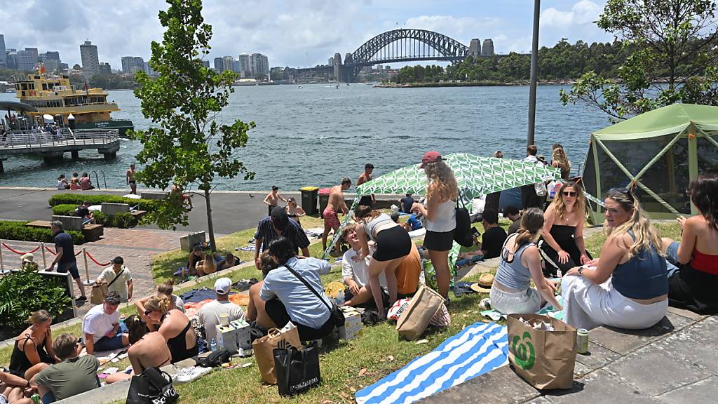 Schon seit dem frühen Morgen campen fröhliche Menschen bei 28 Grad im Schatten rund um den Hafen von Sydney, um das berühmte Feuerwerk zu erleben.