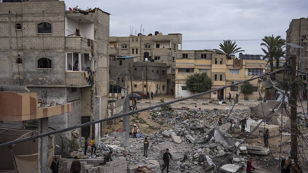 Menschen begutachten die Trümmer nach einem israelischen Luftangriff in Rafah im südlichen Gazastreifen. Foto: Fatima Shbair/AP/dpa