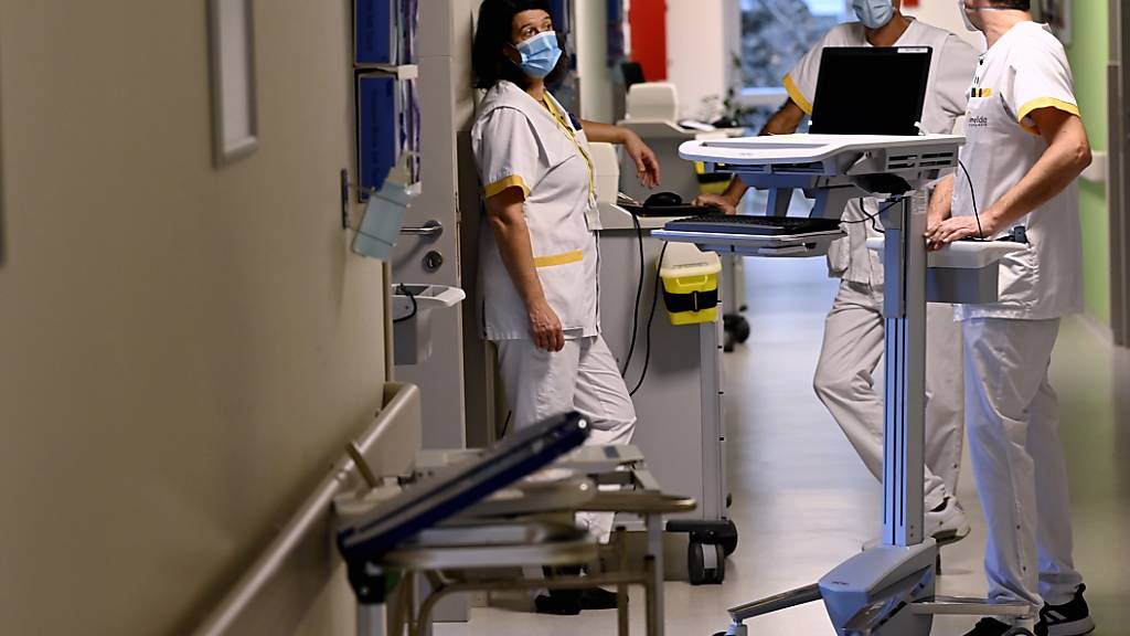 Krankenhauspersonal mit Mund-Nasen-Bedeckung bereitet in Bonheiden die Öffnung einer zusätlich eingerichteten Intensivstation vor. Foto: Dirk Waem/BELGA/dpa