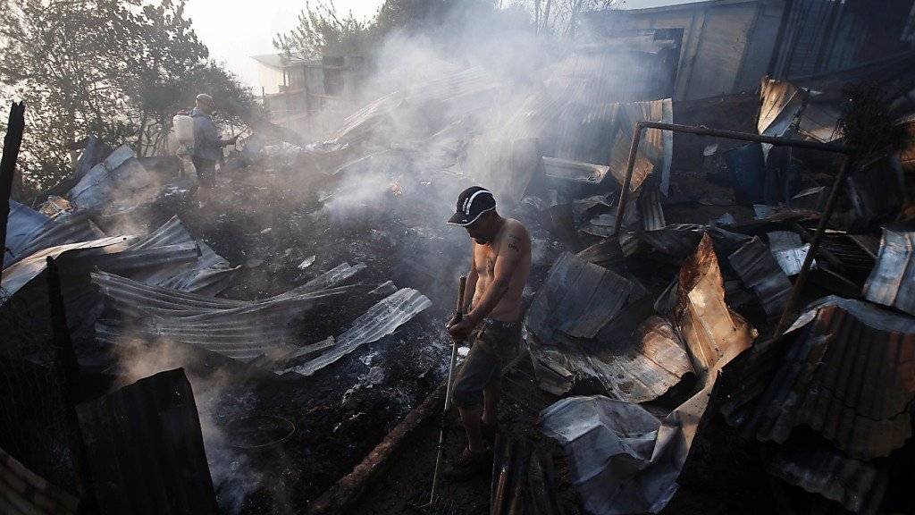 Ein Mann steht zwischen den Ruinen seines abgebrannten Hauses: Der Waldbrand zerstörte 222 Häuser in Valparaíso.