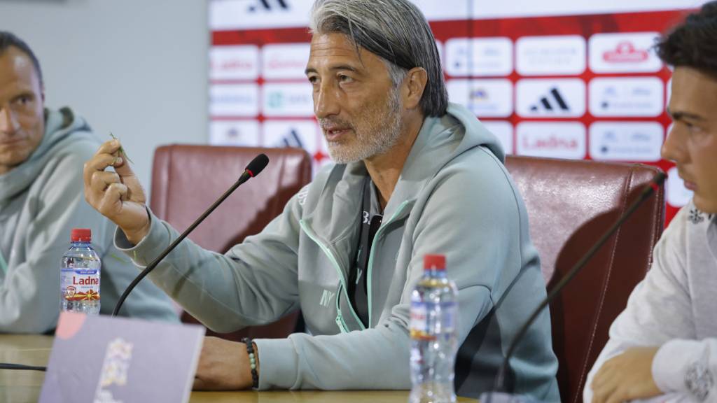 Murat Yakin weist an der Pressekonferenz vor dem Spiel gegen Nordmazedonien auf den nicht geschnittenen Rasen im Stadion in Skopje hin