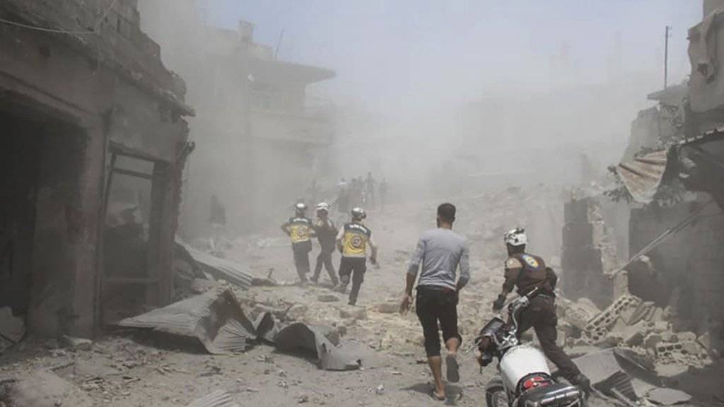 Mitarbeiter der Hilfsorganisation Weisshelme suchen nach einem Luftangriff in der Provinz Idlib nach Überlebenden. (Bild: Hilfsorganisation Weisshelme via AP/Keystone)