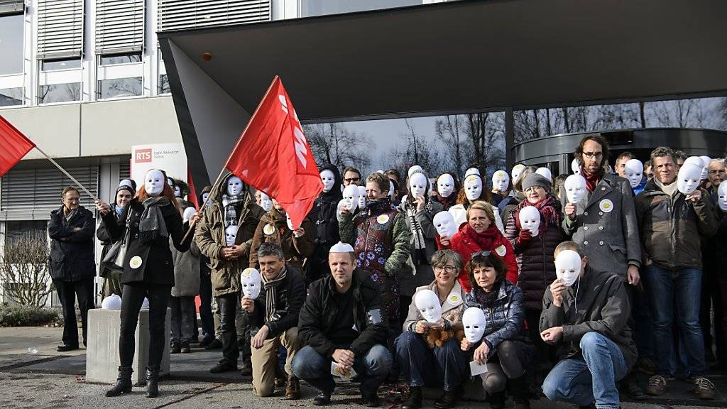 Mit weissen Masken und roten Fahnen demonstrierten am Dienstag in Lausanne RTS-Angestellte gegen den drohenden Stellenabbau in ihrem Unternehmen.