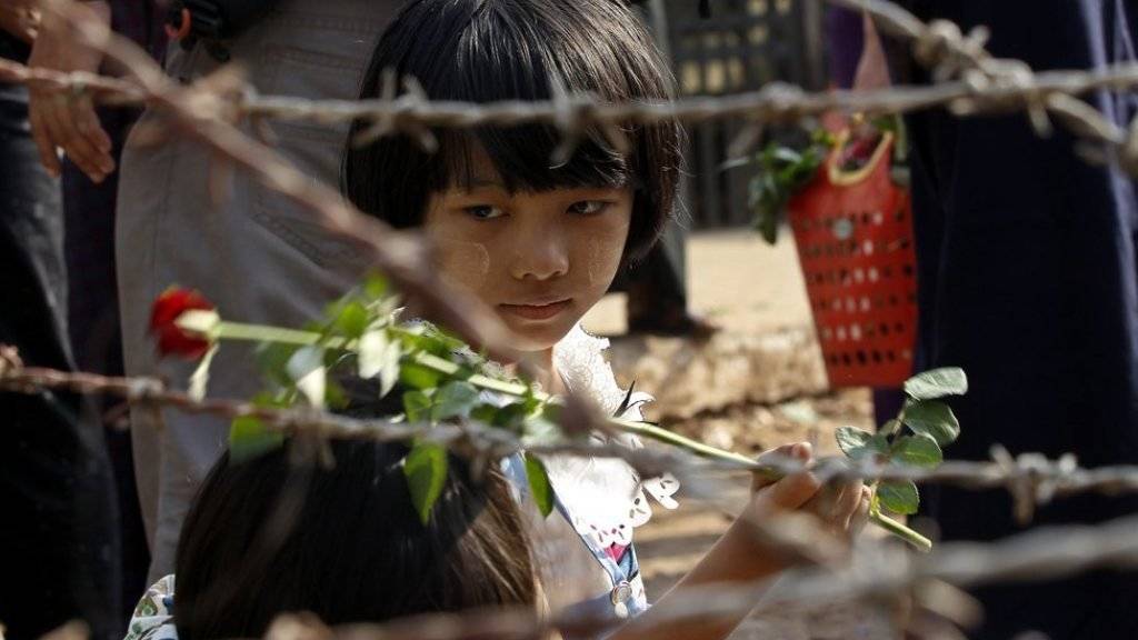 Ein Mädchen, das vor dem berüchtigten Insein-Gefängnis von Rangun auf die Freilassung eines Verwandten wartet, hält eine Rose in der Hand. Seit dem Amtsantritt der neuen Regierung in Myanmar wurden laut der Polizei knapp 200 politische Aktivisten freigelassen.