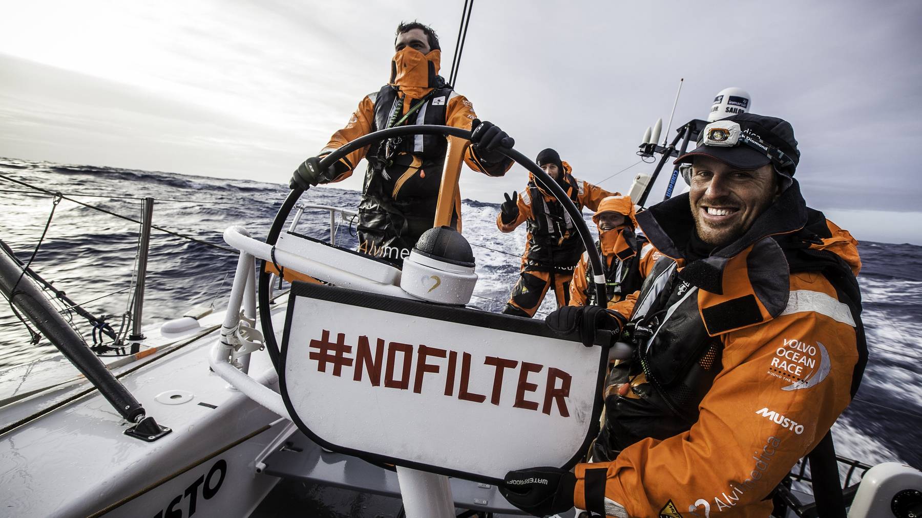 Dave Swete vom Team Alvimedica zeigt bei einem Boot-Rennen ein Schild mit dem Hashtag #Nofilter.