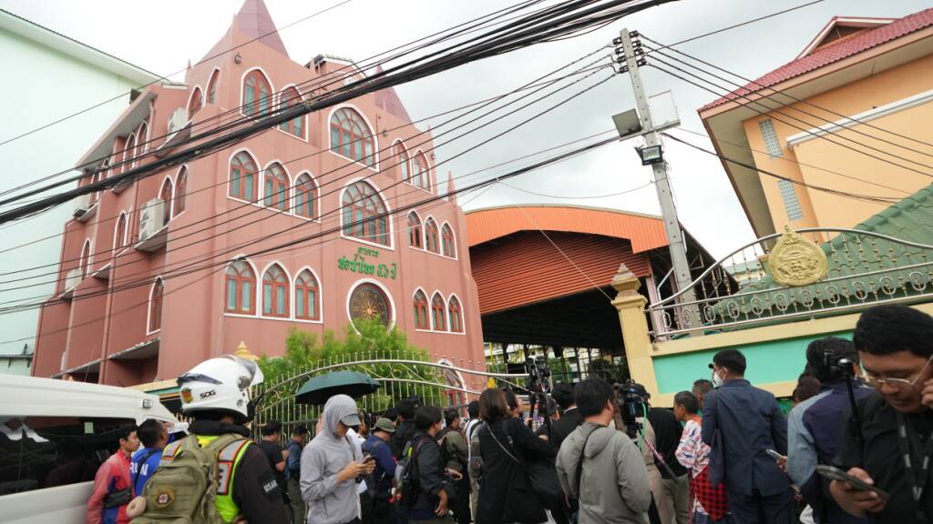 Vor einer Schule in der thailändischen Provinz Nonthaburi versammelt sich eine Menschenmenge, nachdem hier Schüsse gefallen waren. Foto: Sakchai Lalit/AP/dpa