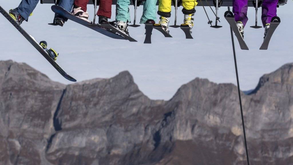 Skifahrer und Snowboarder auf dem Sessellift «Ice Flyer» auf dem Titlis Gletscher. In den ersten fünf Monaten dieses Jahres haben weniger ausländische Touristen in der Schweiz Ferien gemacht. Dies spüren die Hoteliers. (Symbolbild)