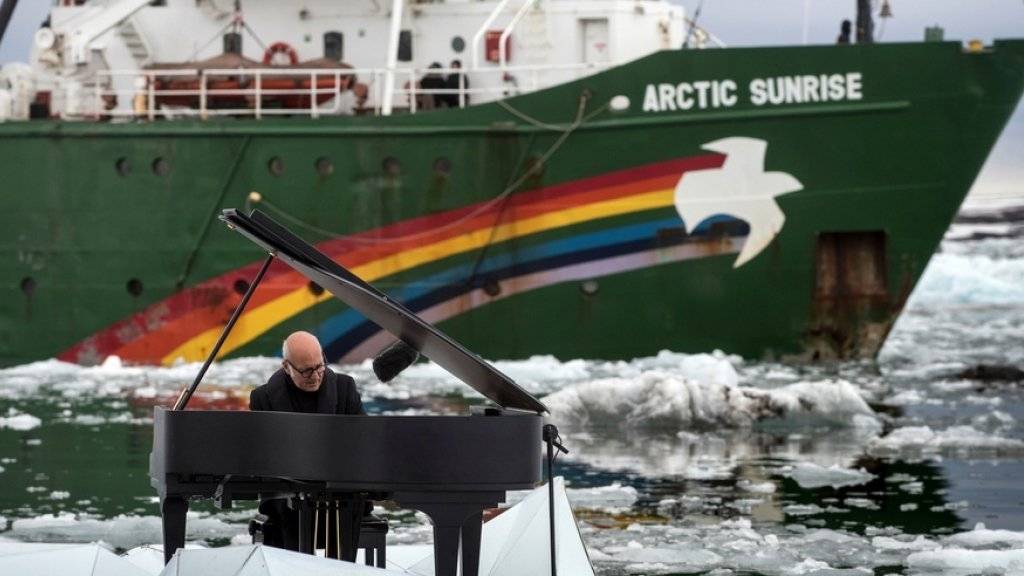 Eis und Wasser können seinem Engagement für die Arktis nichts anhaben: Der italienische Pianist Ludovico Einaudi spielt auf einer künstlichen Eisscholle in Norwegen. Im Hintergrund ankert das Greenpeace-Schiff «Arctic Sunrise».