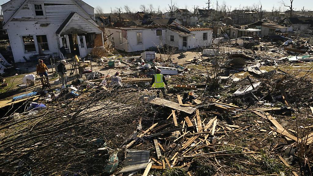 Freiwillige Helfer helfen Martha Thomas (2.v.l) bei der Bergung von Gegenständen aus ihrem zerstörten Haus, nachdem Tornados die Gegend im Bundesstaat Kentucky verwüstet haben. Foto: Gerald Herbert/AP/dpa