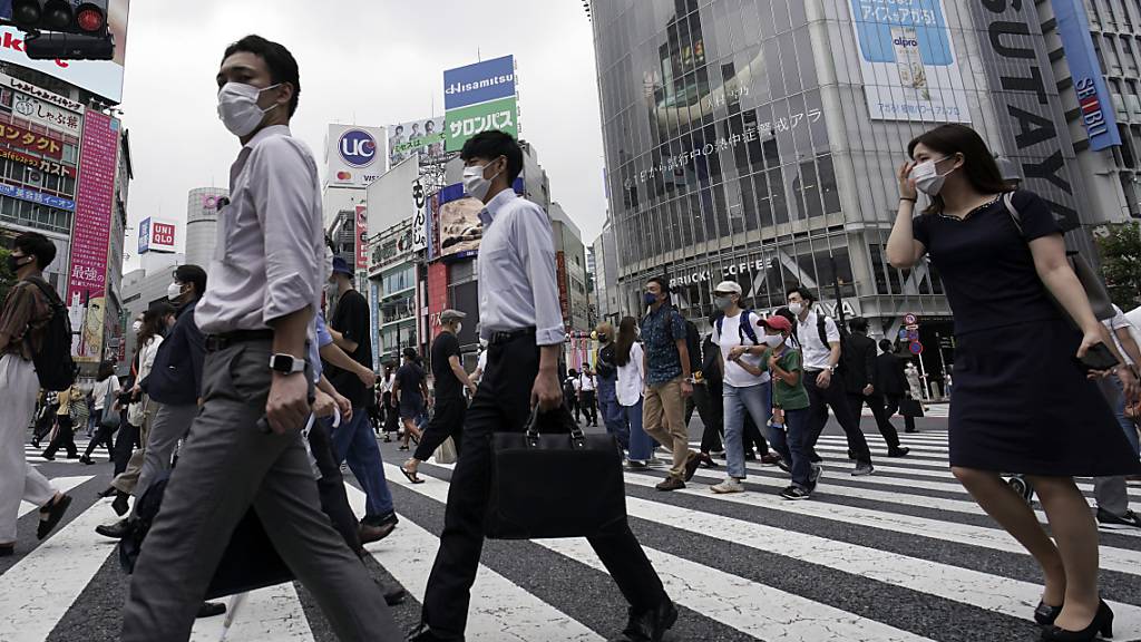 Passanten überqueren eine Straße in dem Stadtbezirk Shibuya. Japans Hauptstadt bestätigte am 31. Juli einen Zuwachs an mehr als 400 Corona-Neuinfektionen. Foto: Eugene Hoshiko/AP/dpa
