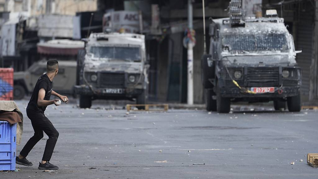 Palästinenser stoßen mit israelischen Sicherheitskräften während einer militärischen Razzia zusammen. Bei einem Militäreinsatz Israels in der Stadt Nablus im besetzten Westjordanland sind zwei bewaffnete Palästinenser getötet worden. Foto: Majdi Mohammed/AP/dpa