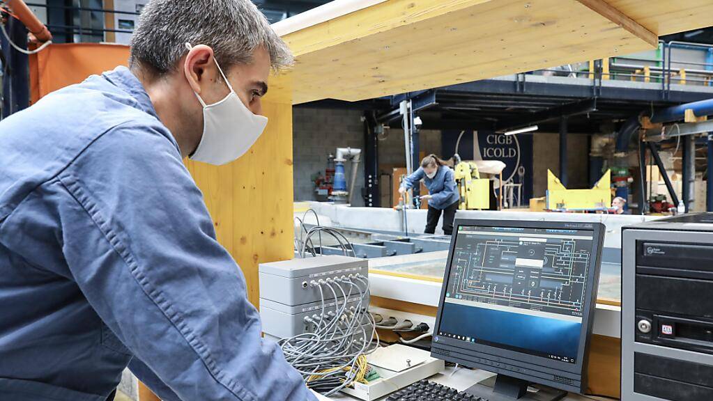 Ein Mitarbeiter der EPFL-Abteilung Plattform für hydraulische Bauwerke (PL-LCH) prüft in  der Computersimulation , wie der geplante Massongex-Bex-Rhône-Damm optimal zu dimensionieren ist: Ziel ist ein Maximum an Energiegewinnung bei einem Minimum an Umwelt-Beeinträchtigung. (Pressebild)