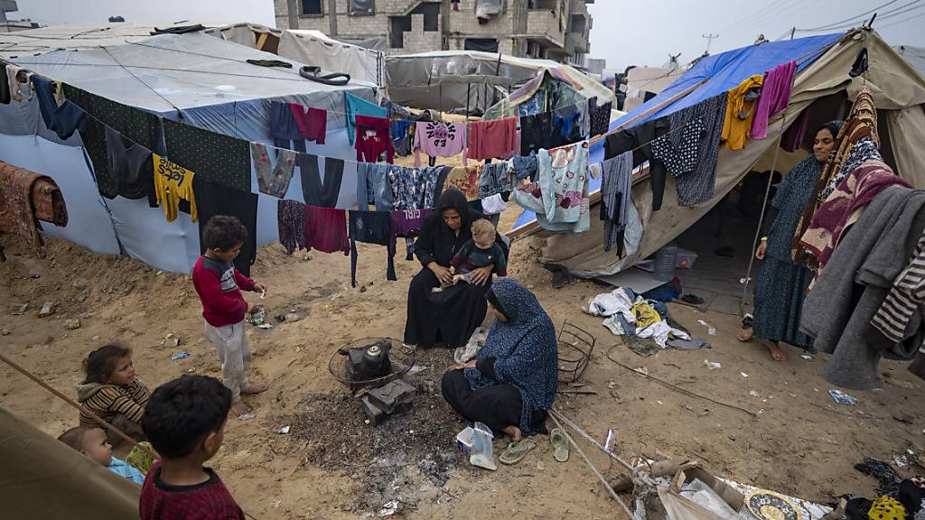 Palästinenser, die durch die israelische Bombardierung des Gazastreifens vertrieben wurden, kochen Tee in einem provisorischen Zeltlager. Nach Angaben des UN-Palästinenserhilfswerks UNRWA sind 40 Prozent der dort lebenden Bevölkerung von einer Hungerkatastrophe bedroht. Foto: Fatima Shbair/AP/dpa