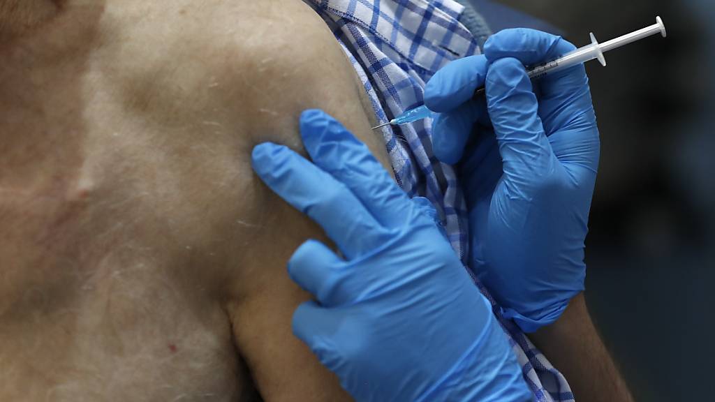 ARCHIV - Eine Krankenschwester verabreicht den Corona-Impfstoff Pfizer/BionTech . Foto: Frank Augstein/AP POOL/PA Wire/dpa