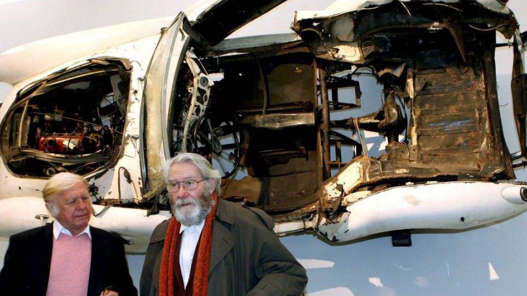 Heinz Mack (links) und Otto Piene stehen 2006 im Kunstpalast Düsseldorf an einer ZERO-Ausstellung vor einem zerstörten Rennwagen des Künstlers Arman (Archiv)