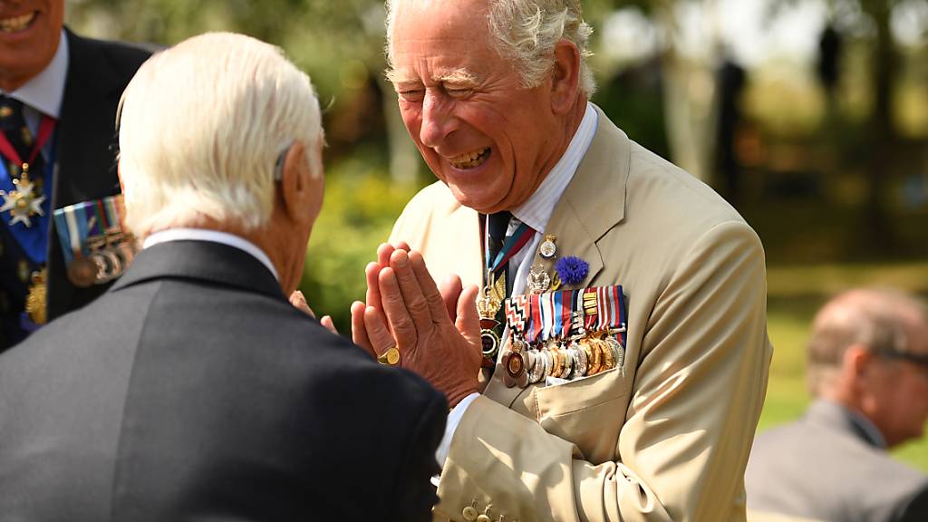 Prinz Charles (r), Prinz von Wales, begrüßt anlässlich des Tages der Kapitulation Japans im Zweiten Weltkrieg am National Memorial Arboretum einen Veteranen. Foto: Oli Scarff/PA Wire/dpa