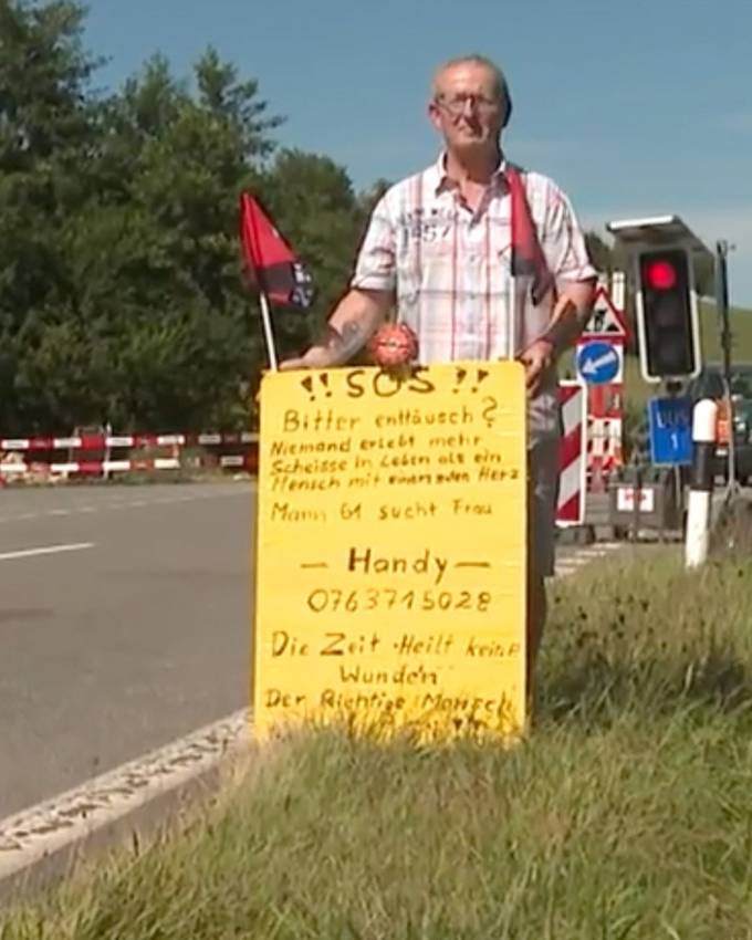 Rico (61) sucht mit einem Schild nach seiner Traumfrau