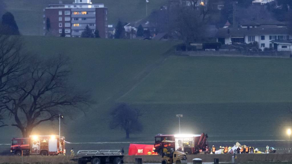 Feuerwehrautos stehen bei der Absturzstelle rund um ein abgestürztes Kleinflugzeug am Sonntag in Grenchen. Von den zwölf Insassen konnten alle elf Fallschirmspringer das Kleinflugzeug verlassen und sicher am Boden landen. Über den Zustand des Piloten war zunächst nichts bekannt.