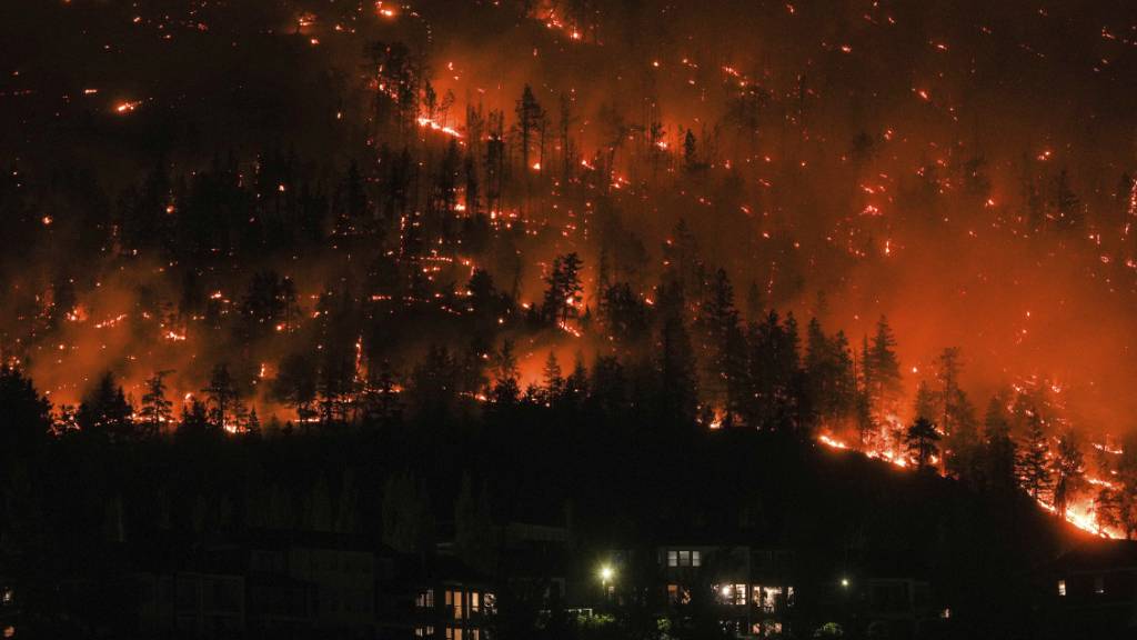 dpatopbilder - Ein Waldbrand am McDougall Creek an einem Berghang oberhalb von Häusern. Foto: DARRYL DYCK/The Canadian Press/AP/dpa