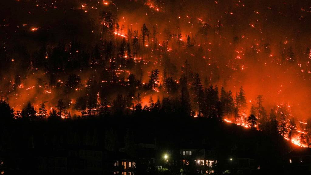 dpatopbilder - Ein Waldbrand am McDougall Creek an einem Berghang oberhalb von Häusern. Foto: DARRYL DYCK/The Canadian Press/AP/dpa