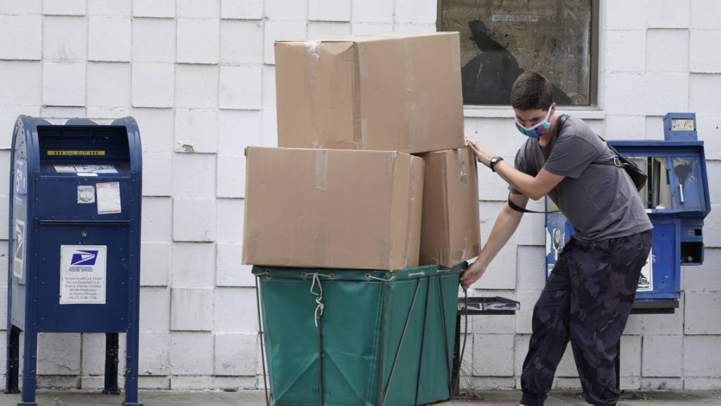 Ein Mann transportiert grosse Paketboxen. 