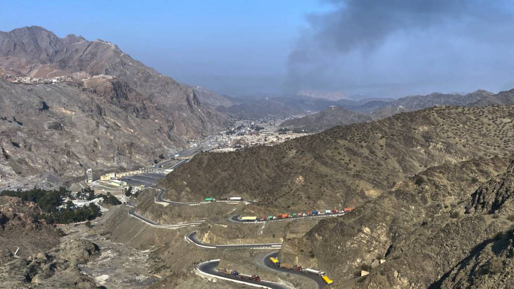 ARCHIV - Nach Zusammenstößen zwischen pakistanischen und afghanischen Streitkräften in der Nähe des Grenzübergangs Torkham in Pakistan steigt Rauch von der afghanischen Seite auf, während Lastwagen am Straßenrand geparkt werden. Foto: Maaz Awan/AP/dpa