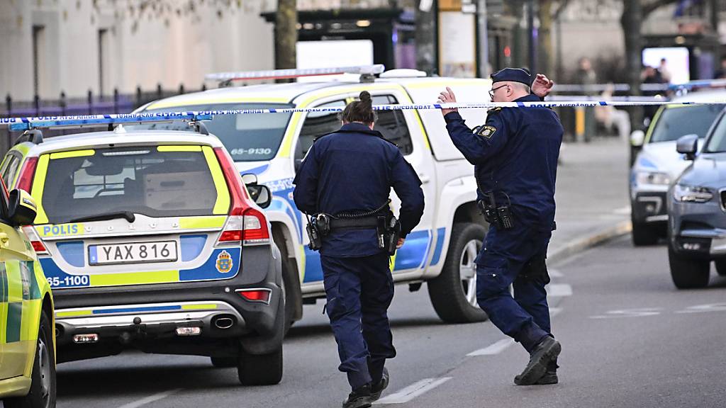 Zwei Polizisten gehen über eine Straße. Bei einem Vorfall an einer Schule im südschwedischen Malmö sind zwei Frauen getötet worden. Foto: Johan Nilsson/TT News Agency/AP/dpa