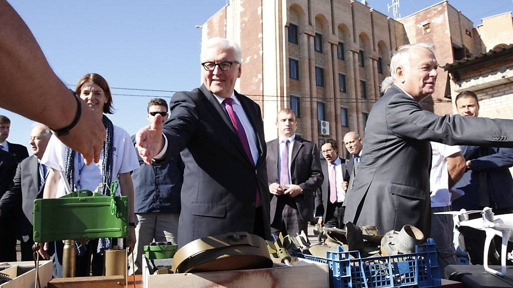 Der deutsche Aussenminister Steinmeier und sein französischer Amtskollege Ayrault grüssen Strassenhändler in der  ostukrainischen Stadt Kramatorsk.