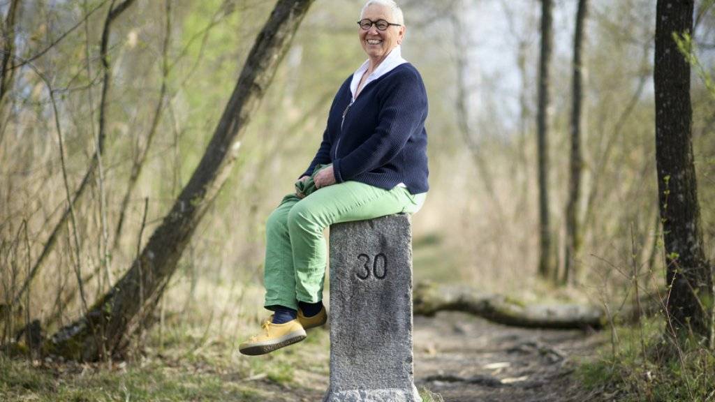 Berta Thurnherr-Spirig, Geschichtensammlerin und Mundartwortspielerin, sitzt im April 2018 auf einem Grenzstein am Alten Rhein in Diepoldsau SG.
