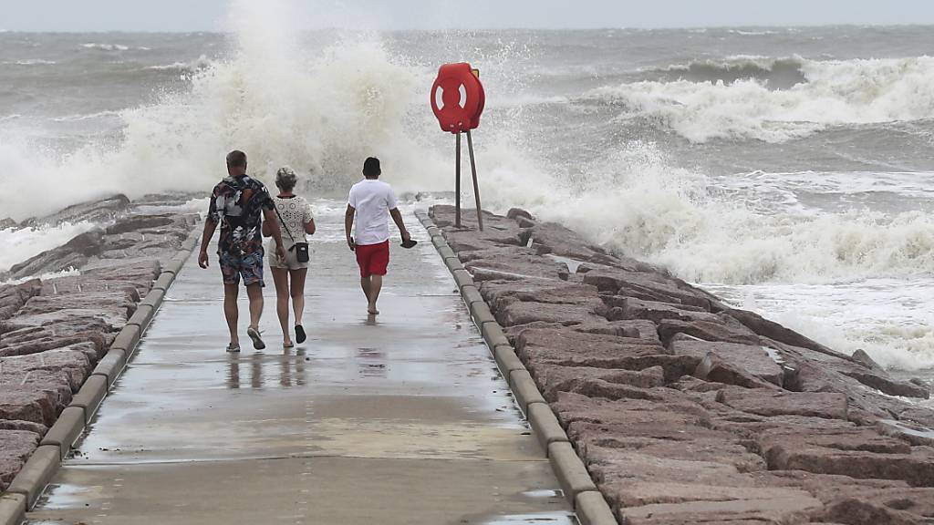 dpatopbilder - Menschen beobachten, wie die Wellen gegen die Felsbucht an der 37th Street prallen, während der Tropensturm «Beryl» auf die texanische Küste zurollt. Foto: Jennifer Reynolds/The Galveston County Daily News/AP/dpa