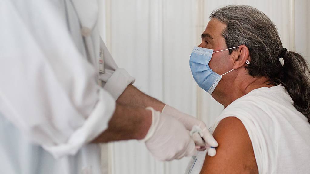 ARCHIV - Ein Mann erhält eine Dosis des Impfstoffs von Pfizer-BioNTech gegen das Coronavirus im Impfzentrum der Ägäisinsel. Foto: Socrates Baltagiannis/dpa