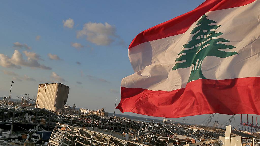 Eine libanesische Flagge weht in der Nähe der Stelle, an der eine Explosion am 4. August 2020 den Hafen von Beirut in die Luft sprengte. Foto: Marwan Naamani/dpa