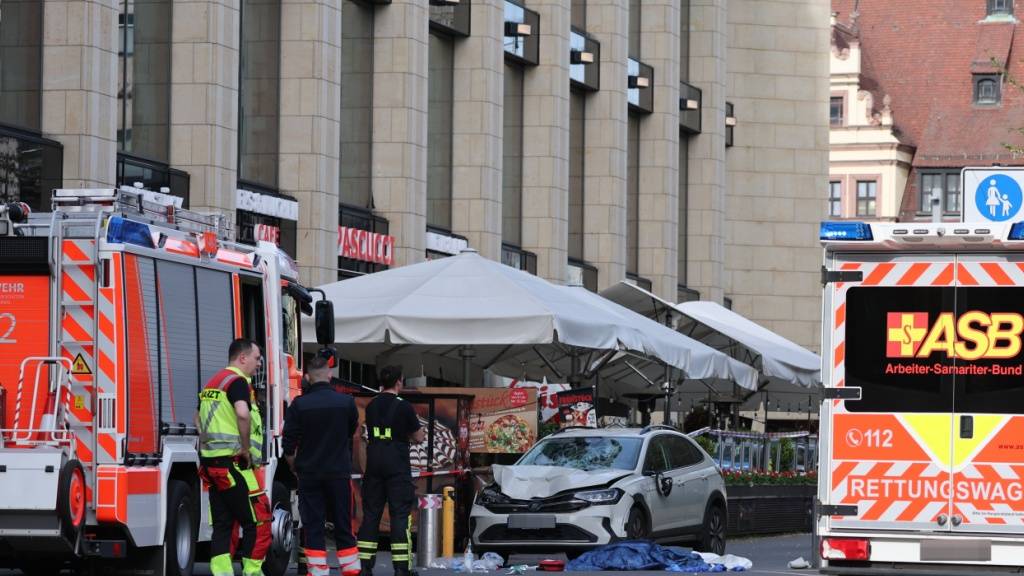 Rettungskräfte stehen an der Stelle, wo ein Auto in Leipzig in eine Menschengruppe gefahren ist. Foto: Jan Woitas/dpa