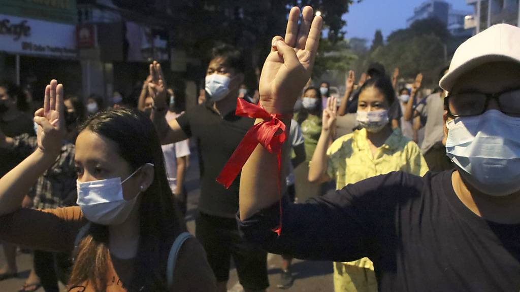 Mehrere Demonstranten heben ihre Hand zum Dreifingergruß während einer Kundgebung in Yangon. Foto: Uncredited/AP/dpa